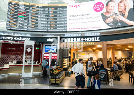 Les passagers, les gens du voyage avec une assurance et des boutiques, change de terminal des départs à l'aéroport de Stansted, Royaume-Uni,Londres Banque D'Images