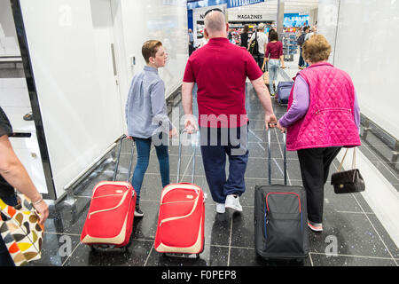 Les passagers, les gens du voyage avec une assurance et des boutiques, change de terminal des départs à l'aéroport de Stansted, Royaume-Uni,Londres Banque D'Images