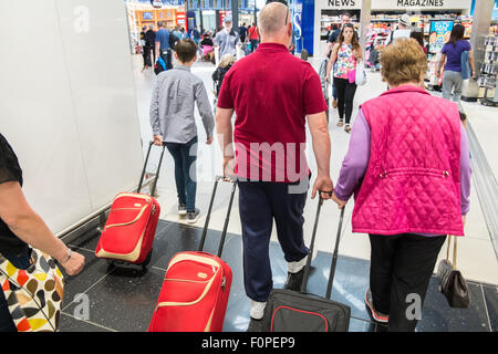 Les passagers, les gens du voyage avec une assurance et des boutiques, change de terminal des départs à l'aéroport de Stansted, Royaume-Uni,Londres Banque D'Images