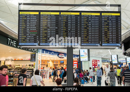 Les passagers, les gens du voyage avec une assurance et des boutiques, change de terminal des départs à l'aéroport de Stansted, Royaume-Uni,Londres Banque D'Images