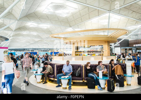 Les passagers, les gens du voyage avec une assurance et des boutiques, change de terminal des départs à l'aéroport de Stansted, Royaume-Uni,Londres Banque D'Images