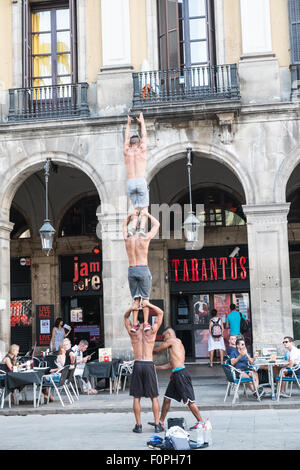 Les artistes de rue, des acrobates produire devant un café de Plaça Reial,Plaza Real,juste à côté de La Rambla de Barcelone,Espagne,. Banque D'Images