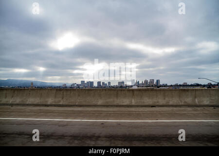 Centre-ville d'Oakland en Californie sur un jour nuageux avec soleil qui rayonne à travers les nuages Banque D'Images