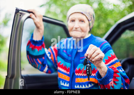 Senior woman holding car key and smiling, portrait Banque D'Images