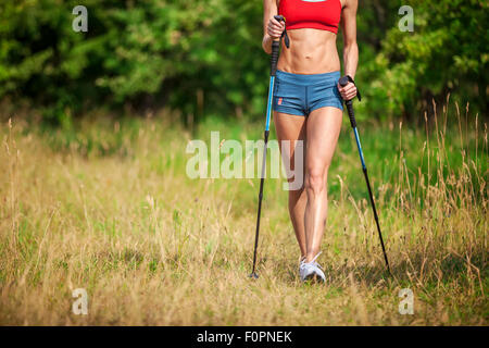 Fit young woman hiking avec des bâtons de marche nordique en été Banque D'Images