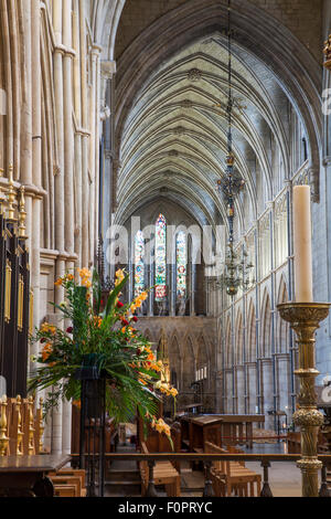 Fleurs et bougies à la recherche vers la nef de la cathédrale de Southwark à Londres avec plafond voûté et l'architecture de l'église Banque D'Images