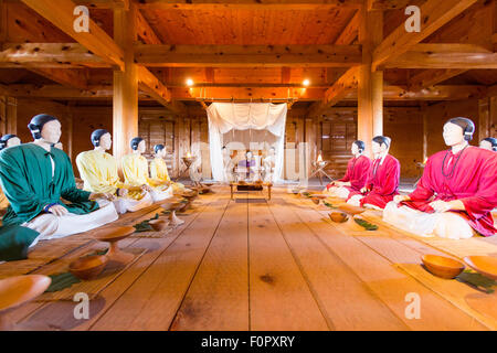 Le Japon, le parc historique Yoshinogari. Intérieur du Palace, de l'intérieur de la salle de l'assemblée des mannequins assis lors de réunion avec les chefs de la colonie. Banque D'Images