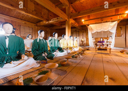 Le Japon, le parc historique Yoshinogari. Intérieur du Palace, de l'intérieur de la salle de l'assemblée des mannequins assis lors de réunion avec les chefs de la colonie. Banque D'Images