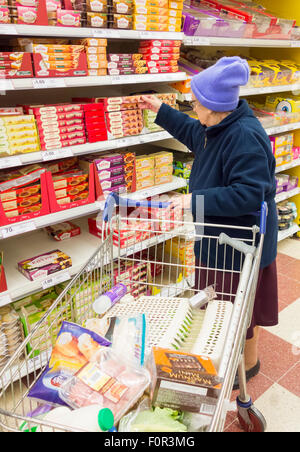 Dame âgée dans son 90 shopping en supermarché Tesco. L'Angleterre. UK Banque D'Images