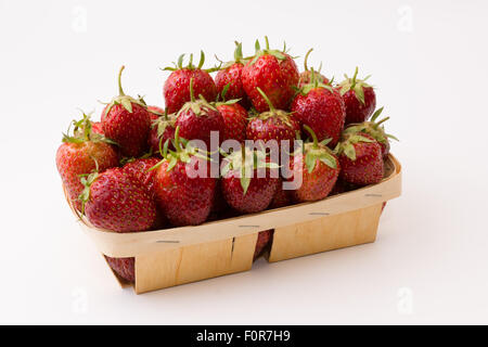 Boîte en bois plein de fraises juteuses mûres sur un fond blanc Banque D'Images
