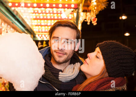 Couple eating Cotton Candy sur la paroisse de noël juste Banque D'Images