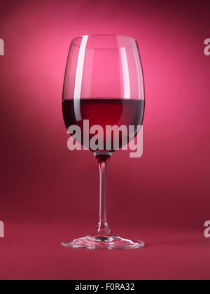 Verre à vin rouge isolé sur fond rouge Banque D'Images