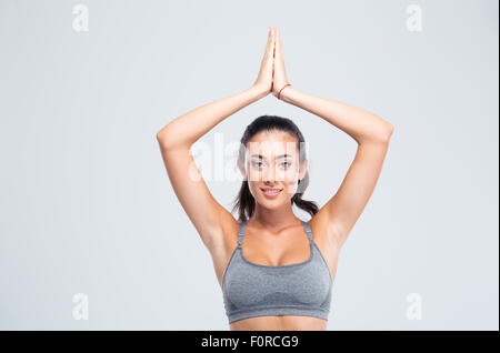 Femme fitness heureux avec joint les mains sur la tête isolé sur un fond blanc. Looking at camera Banque D'Images