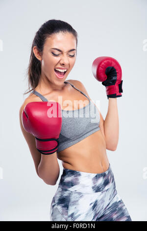 Portrait d'une femme avec succès sports gants de boxe pour célébrer sa victoire, isolated on a white backgorund Banque D'Images