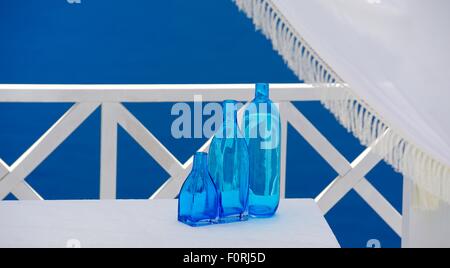 Bouteilles en verre bleu sur un tableau blanc lors d'une salle de mariage à Santorin Grèce Banque D'Images