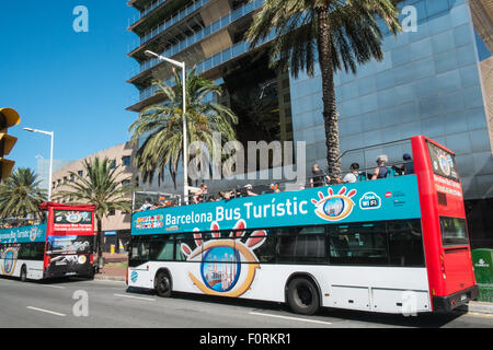 Deux,hop-on hop-off bus touristiques à la base de la tour Mapre une des tours jumelles en Olimpic de Barcelone, Catalogne, Espagne Banque D'Images