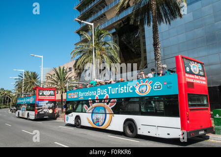 Deux,hop-on hop-off bus touristiques à la base de la tour Mapre une des tours jumelles en Olimpic de Barcelone, Catalogne, Espagne Banque D'Images