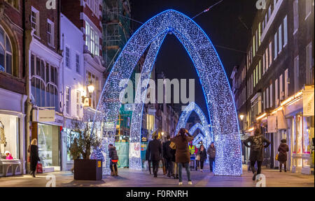 Personnes marchant le long de South Molton St à l'heure de Noël, qui a été décoré avec de grandes arches de Noël bleues, Londres, Royaume-Uni Banque D'Images