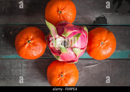 Fruit du dragon et des oranges sur sol en bois Banque D'Images