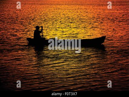 Silhouette d'un homme seul d'un canot à rames dans l'eau reflétant les couleurs coucher de soleil spectaculaire. Illustration de Vecteur