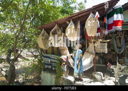 Woman shopper inspecte les hamacs dans une boutique sur l'île de la rivière Cuale, un marché dynamique place à Puerto Vallarta, au Mexique. Banque D'Images