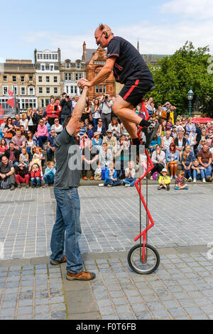 Artiste de rue d'effectuer sur un monocycle au cours de l'Edinburgh Fringe Festival et impliquant un membre du public, le tertre Banque D'Images