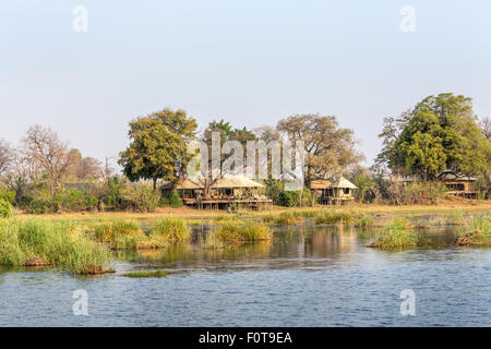 Camp au bord du lac artificiel de Zarafa bâtiments sur pilotis de bois par le lac, Selinda Concession, Okavango Delta, Kalahari, au nord du Botswana, Afrique australe Banque D'Images