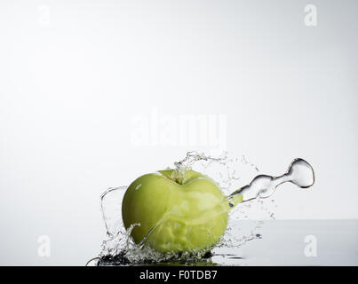 Green Apple dans l'éclaboussure de l'eau sur fond blanc Banque D'Images