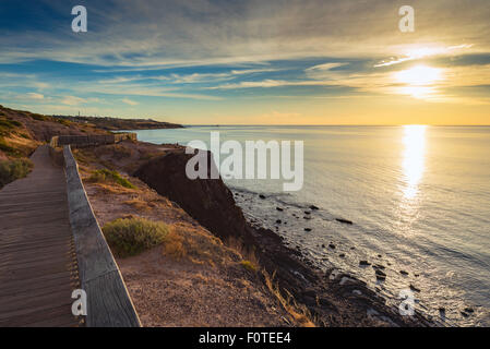 Sentier polyvalent le long la plage de rochers au coucher du soleil Banque D'Images