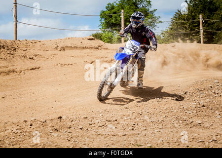 Motocycliste de motocross sur une piste poussiéreuse sur un jour étés dans Calverstown, comté de Kildare, Irlande. Banque D'Images