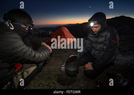 Les randonneurs chauffage de l'eau devant leur tente sur un éperon crête calcaire dans Mehedinti, Roumanie, le géoparc du Plateau Octobre 2012 Banque D'Images