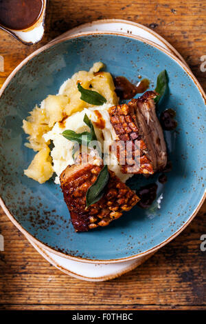 Flan de porc avec grésillement, purée de pommes, de la compote de pomme et de feuilles de sauge frites Banque D'Images