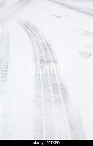 Les traces de pneus sur la glace et la neige sur une route Banque D'Images
