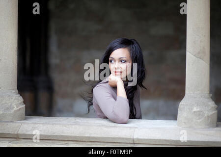 Olive-skinned woman leaning on wall est situé dans le cloître de la cathédrale de Norwich Banque D'Images