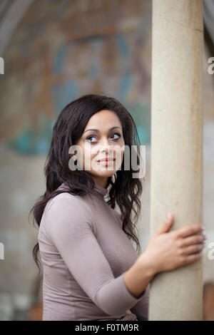 Lumière naturelle portrait de femme à la peau d'olive dans le cloître de la cathédrale de Norwich Banque D'Images