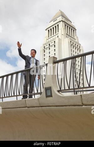 Business man standing on walkway, forme, souriant, l'Hôtel de ville de Los Angeles, Californie, USA Banque D'Images