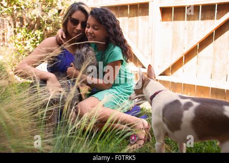 Mère et fille petting dog in garden Banque D'Images