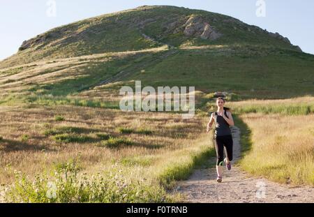 Young woman running on hillside voie Banque D'Images