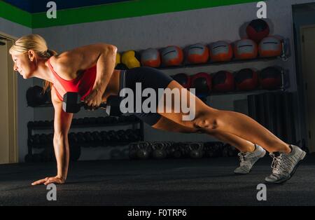 Jeune femme faisant un bras push up in gym Banque D'Images