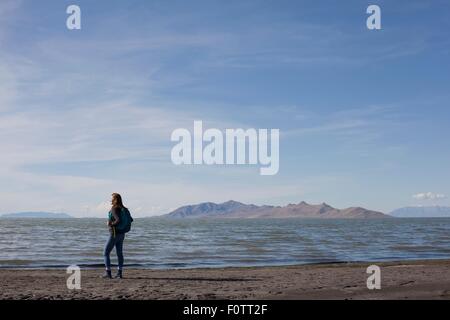 Vue arrière du jeune femme debout à bord de l'eau à la remarquer, Grand lac Salé, Utah, USA Banque D'Images