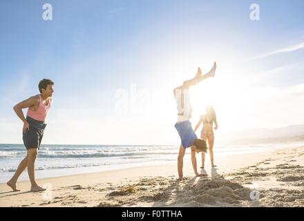 Groupe d'amis de jouer sur la plage Banque D'Images