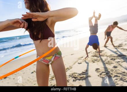 Groupe d'amis de jouer sur la plage Banque D'Images