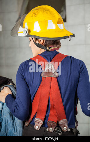 Vue arrière du firewoman en uniforme Banque D'Images