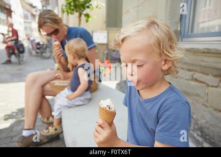 Mère et fils assis à l'extérieur manger icecream Banque D'Images