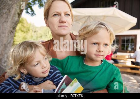 La mère et les deux fils ensemble, assis à l'extérieur Banque D'Images