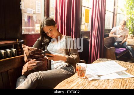 Mid adult woman looking at smartphone Banque D'Images