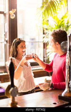 Couple un toast tenue shot glasses Banque D'Images