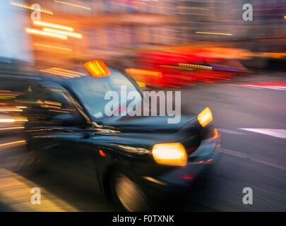 Black Cab motion blurred au crépuscule, London, UK Banque D'Images