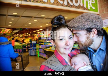 Mère et père avec bébé fils in supermarket Banque D'Images