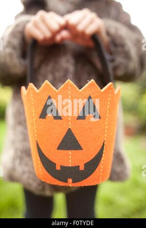 Girl holding up halloween citrouille sac pour trick or treating Banque D'Images